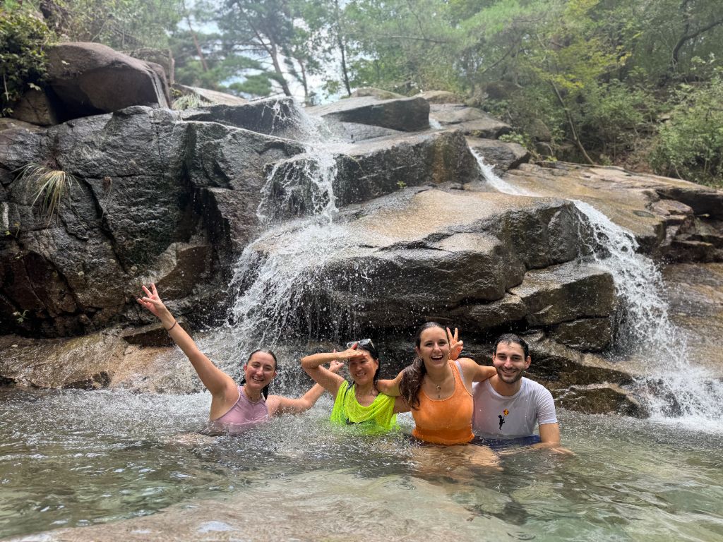 Group swimming under waterfall