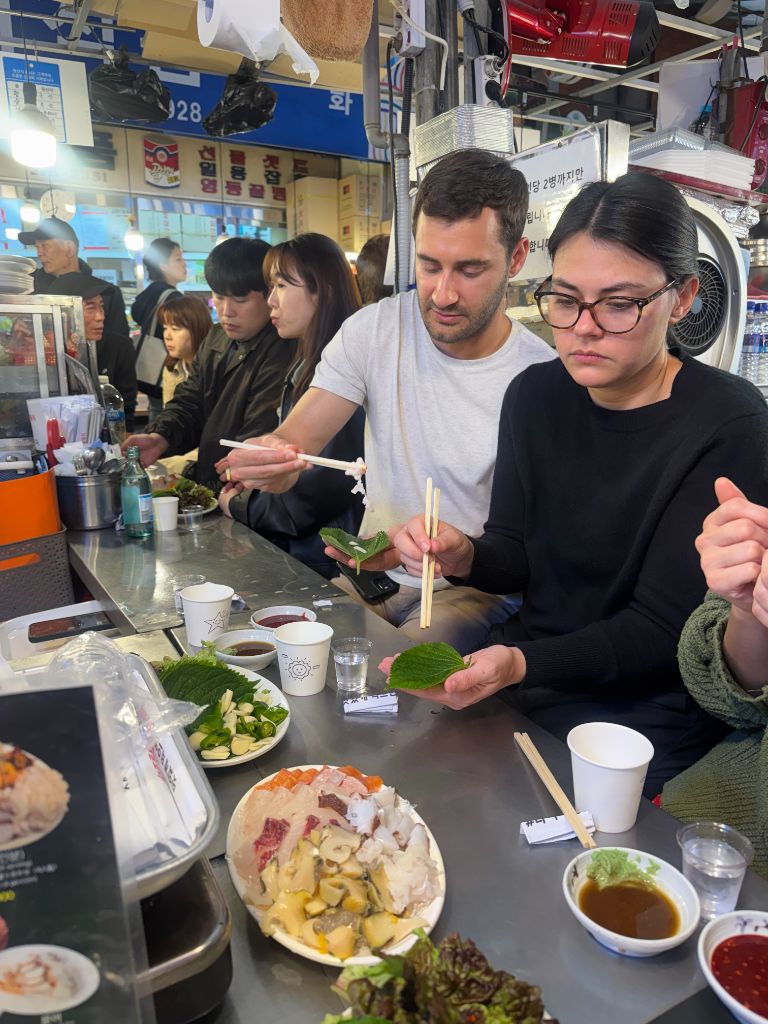 Guests wrapping fresh fish at market