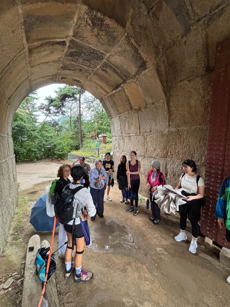 Group walking through historic stone arch gate