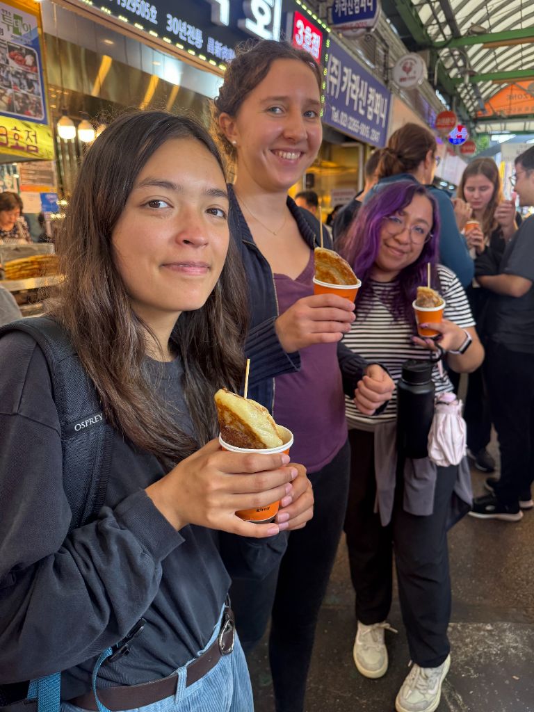 Guests eating hotteok at street stall