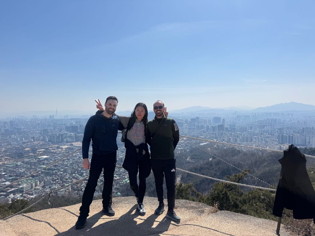 Group at rocky summit with city panorama