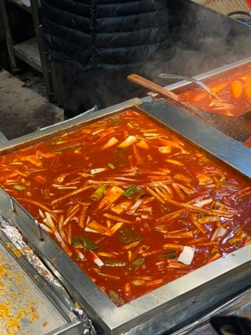 Spicy tteokbokki bubbling at market stall